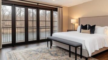 A bedroom with a large bed and a view of the river photo