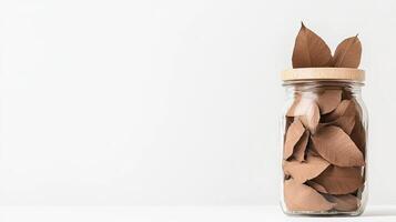 A jar filled with brown leaves on a white background photo