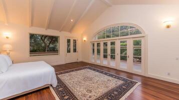 A bedroom with a large bed and a rug photo