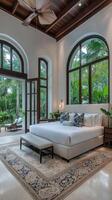 A bedroom with a large bed and large windows photo