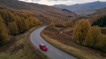 A red truck driving down a winding road in the mountains photo