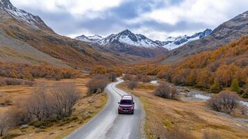 A red truck driving down a mountain road in the mountains photo