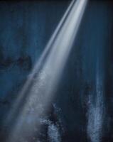 A dark room with light coming from the ceiling photo
