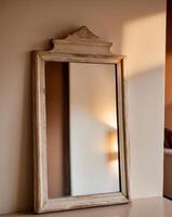 un Clásico de madera enmarcado espejo reflejando ligero en un acogedor interior ajuste exhibiendo calor foto