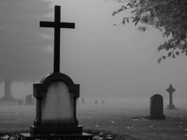 A black cross sitting on top of a grave in a cemetery. photo