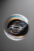 Iridescent soap bubble floating in darkness. photo