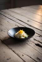 The black dish on the ancient table was a light and delicious meal created with lemon zest. photo