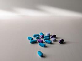 The table is covered with blue and purple pills. photo