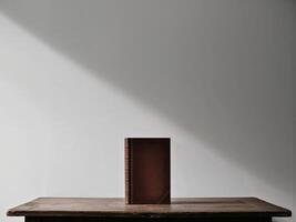 A book is sitting on a table in front of a wall. photo
