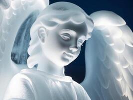 A white angel statue with wings on a blue background photo