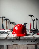 Red construction helmet on wooden surface with tools in the background. photo