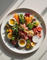 A plate of food with eggs, ham, cheese, and vegetables photo
