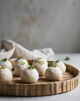 Closeup of steamed rice balls with scallions on a bamboo tray photo