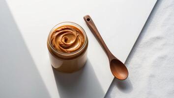 A jar of peanut butter with a wooden spoon in it photo