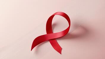 Red Ribbon Shaped Like a Heart for Awareness and Support in Health Causes on a Soft Pink Background photo