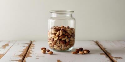 A glass jar filled with nuts on a wooden table photo