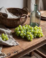 Fresh green grapes and a glass bottle create a rustic still life on an antique wooden table surrounded by earthy textures in a cozy setting photo