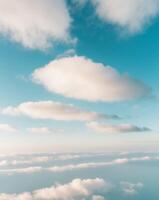 A view of the sky from above with clouds and a plane photo