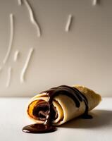 A chocolate covered crepe with a drizzle of chocolate photo