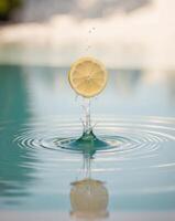 Fresh lemon slice splashes into crystal clear water creating mesmerizing ripples and reflections in a tranquil setting photo