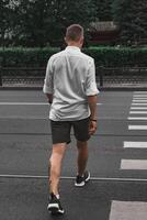 A man crossing the street in casual attire, embodying a sense of style and freedom photo