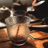 Experience elegant tea pouring with stunning textured glassware that enhances the moment photo
