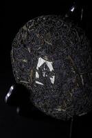 A closeup image of a uniquely compressed tea cake against a dark background enhances its features photo
