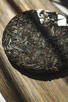 A Premium Loose Leaf Puerh Tea Disc is beautifully displayed on a Wooden Surface photo