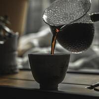 Pouring steaming coffee into a rustic ceramic cup is a delightful and comforting experience photo
