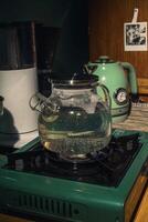 A teapot rests on the stove as boiling water bubbles in a cozy kitchen, creating serenity photo