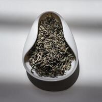 An Elegant and Visual Display of Various Dry Tea Leaves Presented in a Unique Bowl Design photo