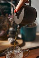 Pouring Tea From a Traditional Kettle Creates an Inviting and Cozy Atmosphere to Enjoy photo