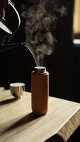 Pouring hot water into a stylish thermal bottle enhances your beverage experience photo