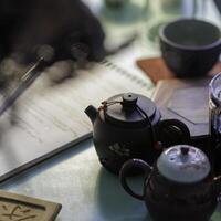 Setting up a tea ceremony with elegant teapots and a notepad for notes and reflections photo