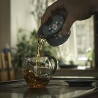 The Art of Tea Pouring a Hot Brew into a Beautiful Glass Cup for Enjoyment and Relaxation photo