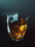 An Elegant Glass Pitcher Filled with Amber Liquid Set Against a Dark Background for Contrast photo