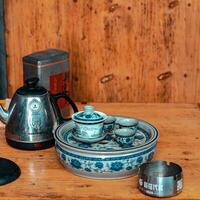 A traditional tea set complete with a kettle elegantly displayed on a rustic wooden table photo