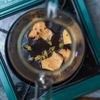 Aromatic Spices Infusing Delightfully in a Rich Dark Beverage for Ultimate Enjoyment photo