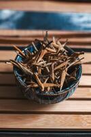 A collection of natural dried sticks elegantly arranged in a blue bowl on a rustic wooden surface photo