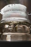 CloseUp of a Beautiful Teapot with Steam Rising Above and Fresh Tea Leaves Inside photo
