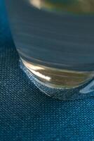 A CloseUp Image of a Glass Set Against a Soft Blue Fabric Background with Textures photo