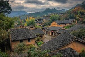 Hillside village with traditional houses, autumn foliage, and moody sky. photo