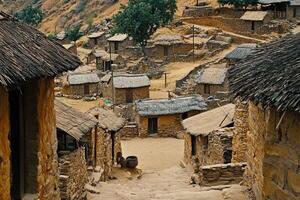 Hillside village with traditional thatched-roof houses and stone walls. photo