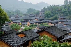 Misty mountain village with traditional houses and dark tiled roofs. photo