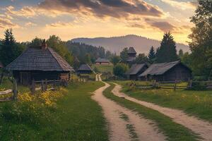 Scenic sunset view of a quaint village nestled in a verdant valley, featuring traditional wooden houses and a winding dirt road. photo