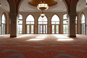 Sunlit interior of a large hall with arched windows and patterned carpet. photo
