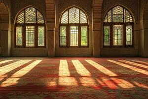 Sunlit prayer room interior with arched windows and patterned carpet. photo