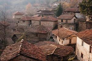 Panoramic view of a traditional stone village with terracotta roofs, nestled in a valley. photo
