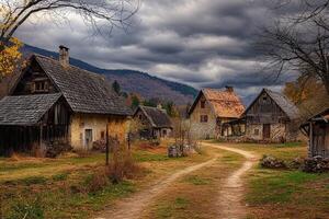 Rustic village path, autumnal landscape, old stone houses, cloudy sky, mountain backdrop. photo