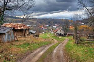 Rustic village road leading to houses under dramatic sky. photo